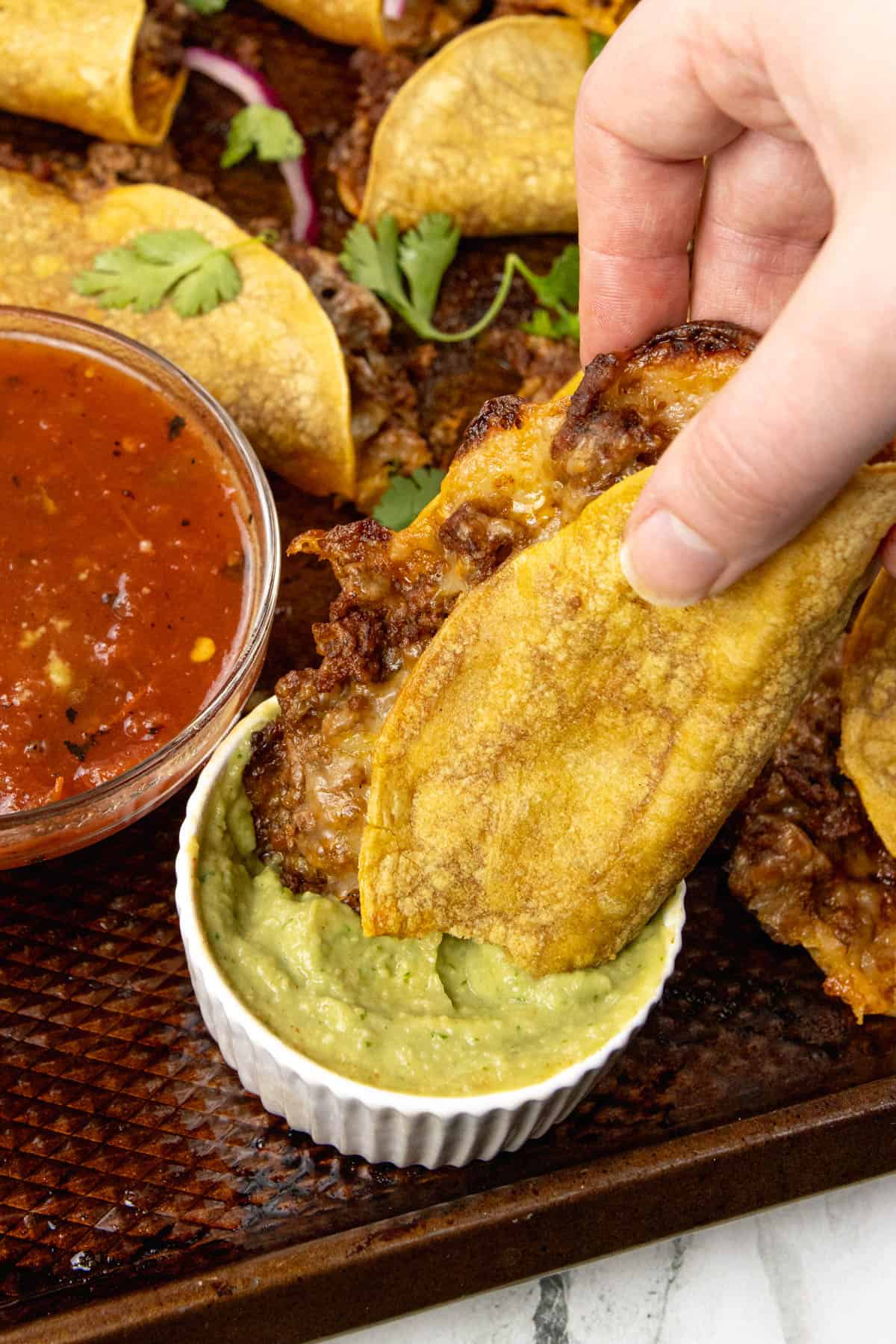 Crispy Beef Tacos Dipped into guacamole