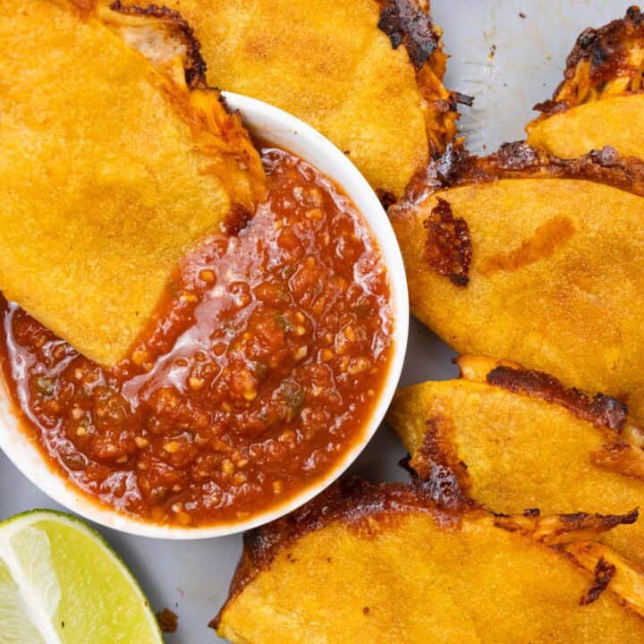 Crispy Shredded Chicken Tacos Finished with Salsa and lime Closeup